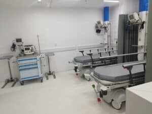 Sala de urgencias hospitalaria con camillas y equipos médicos.