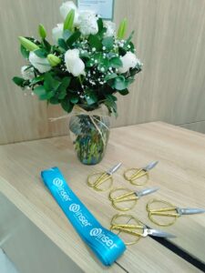 Ramo de flores blancas y cinta azul Inser sobre mesa.