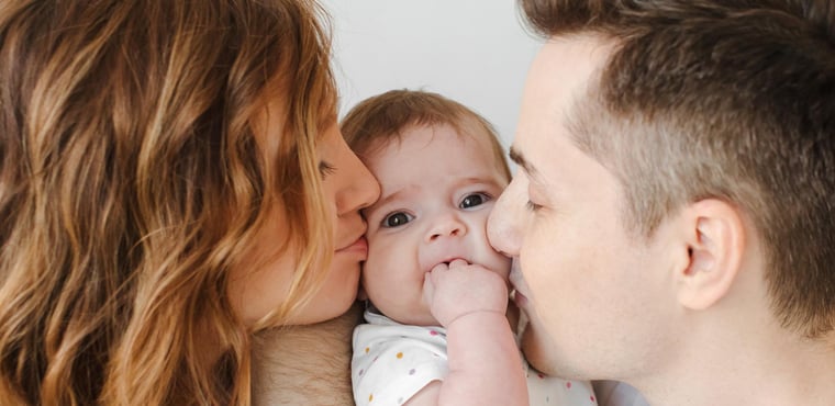 Padres besan a su bebé